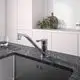 Küchenarmatur aus Chrom von Ideal Standard, mit einem ausgestreckten Auslauf und einem leicht zu bedienenden Hebel, montiert über einer Edelstahlspüle auf einer dunklen Arbeitsplatte.